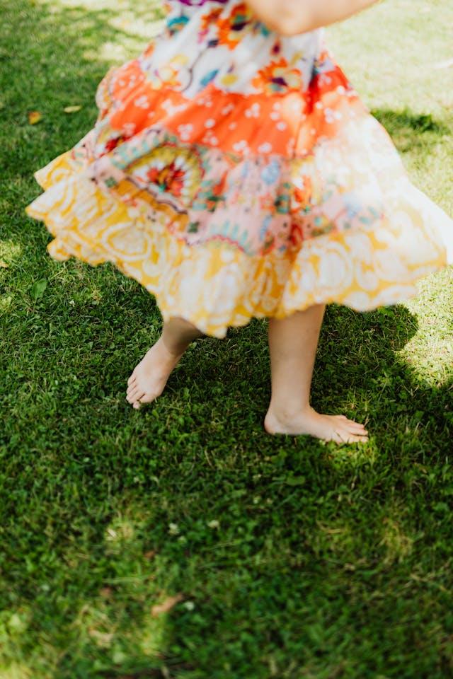 femme avec une robe colorée qui marche dans l'herbe