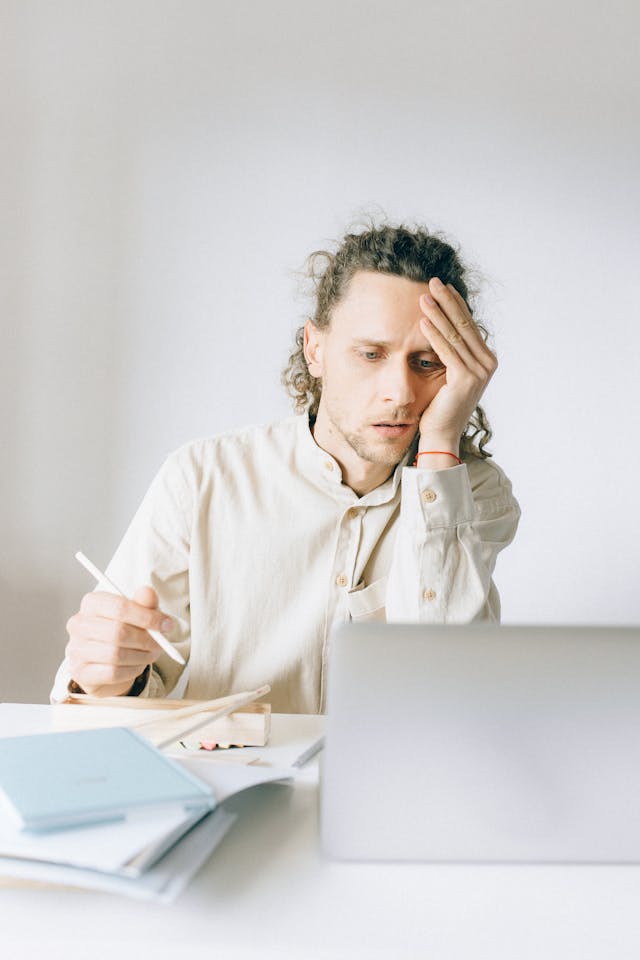 homme devant son pc qui semble un peu fatigué